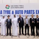 An exhibition hall bustling with activity at the 3rd UAE China Tire & Auto Parts Expo 2024, featuring various booths and attendees engaging in discussions.